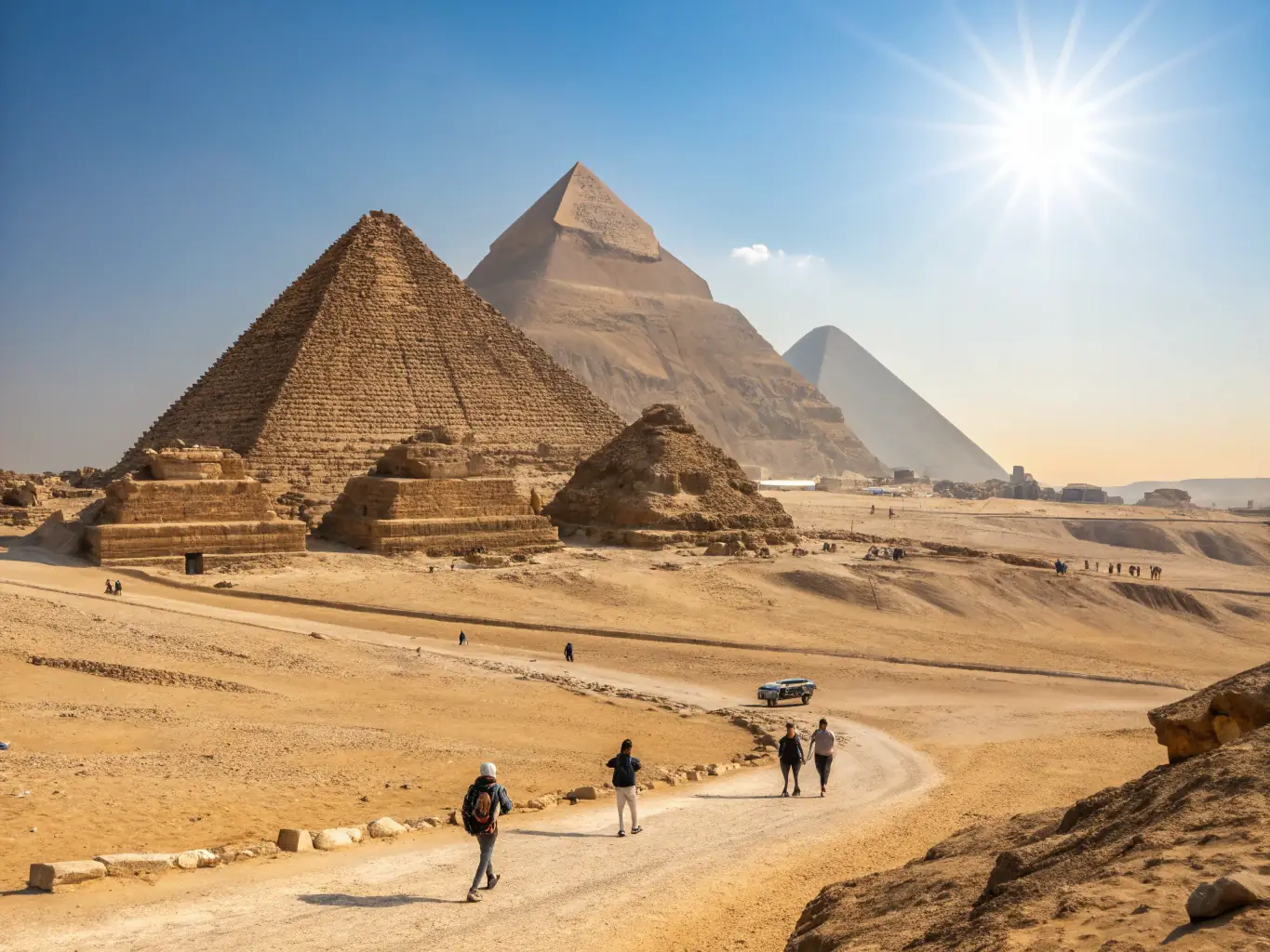 A high-angle shot capturing the majestic pyramids of Giza at sunset, with tourists exploring the base and camels resting nearby, conveying the historical grandeur of Egypt.